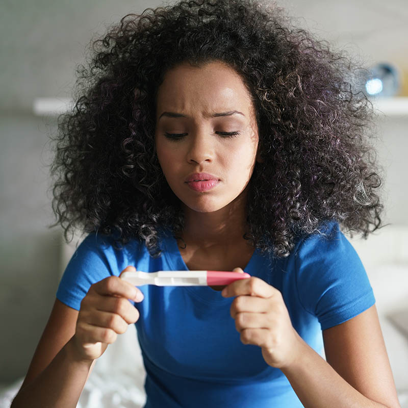 girl looking at pregnancy test